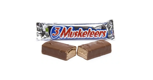 A 3 Musketeers chocolate bar, broken in half to show the inside of the bar, with it's packaging in the background